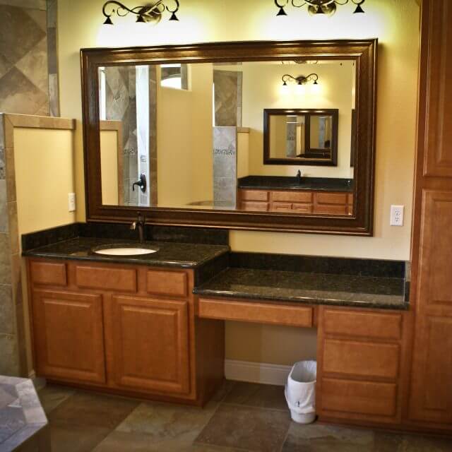 Master bathroom sink and vanity with granite countertops and modern wood cabinets