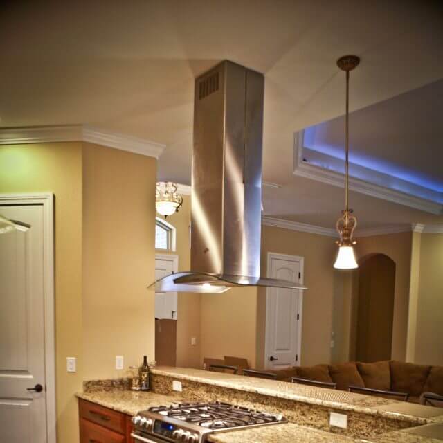 Modern stainless steel vent hood over range and transitional cabinets