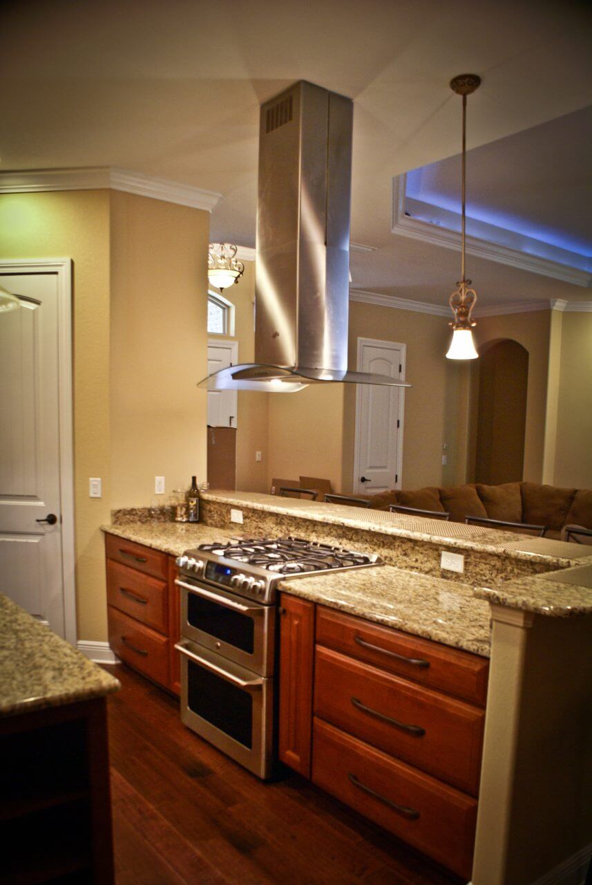 Modern stainless steel vent hood over range and transitional cabinets