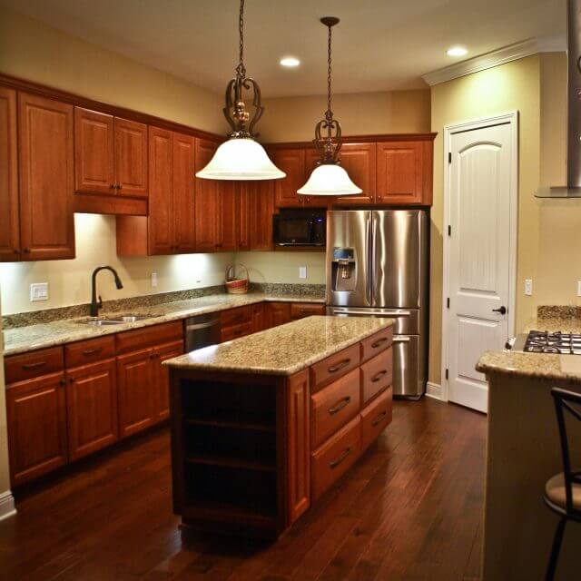 Transitional kitchen with rich wood cabinets, granite countertops and wood floors