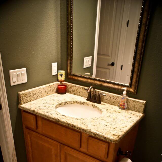 Custom bathroom cabinetry with granite countertop and backsplash