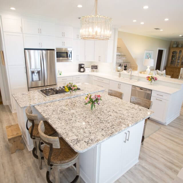 Open floor plan kitchen remodeled with white shaker cabinets.
