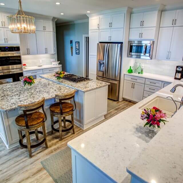 Sleek modern kitchen with stacked Shaker cabinets, quartz countertops and glass subway tile backsplash