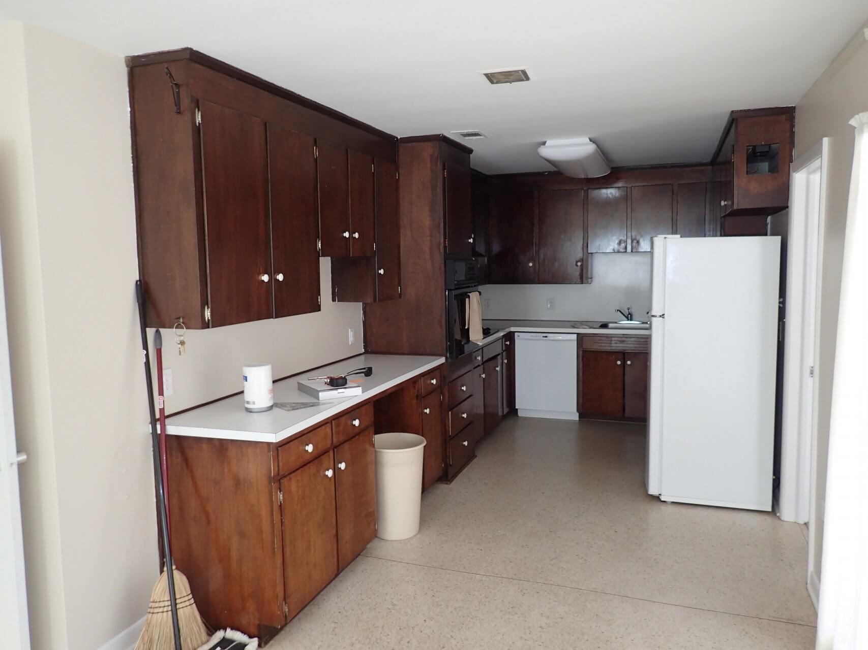 Before: Old dark brown cabinets in kitchen remodel and linoleum floor